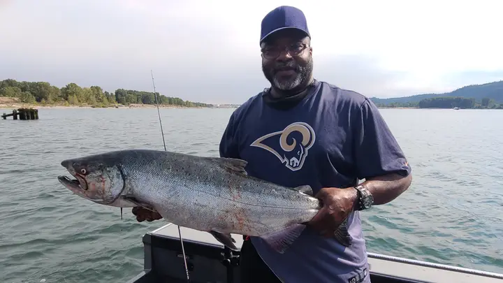 A man holding a large chinook salmon on the Columbia River