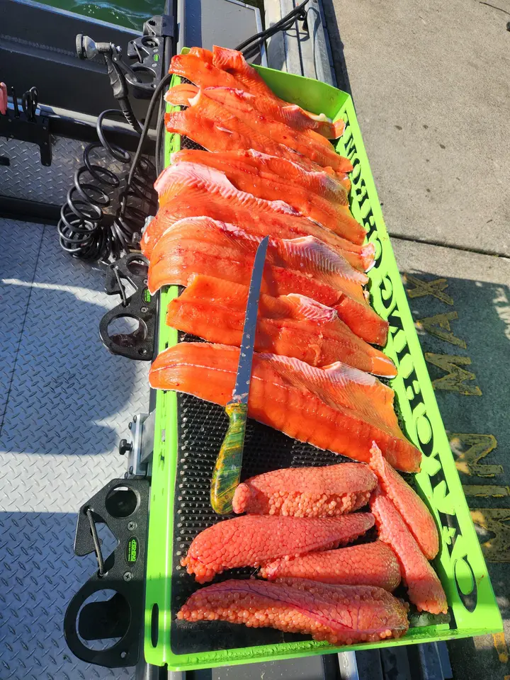 Salmon fillets and roe on a Catching Chrome branded cutting board