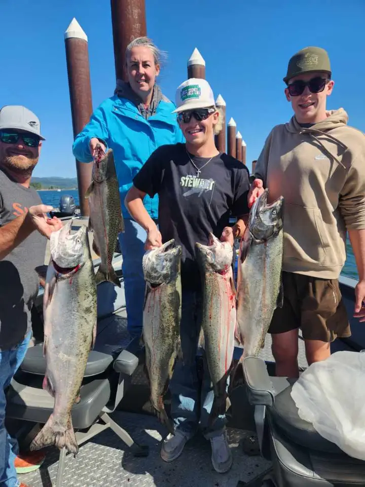 A family of four on the dock with a chinook salmon